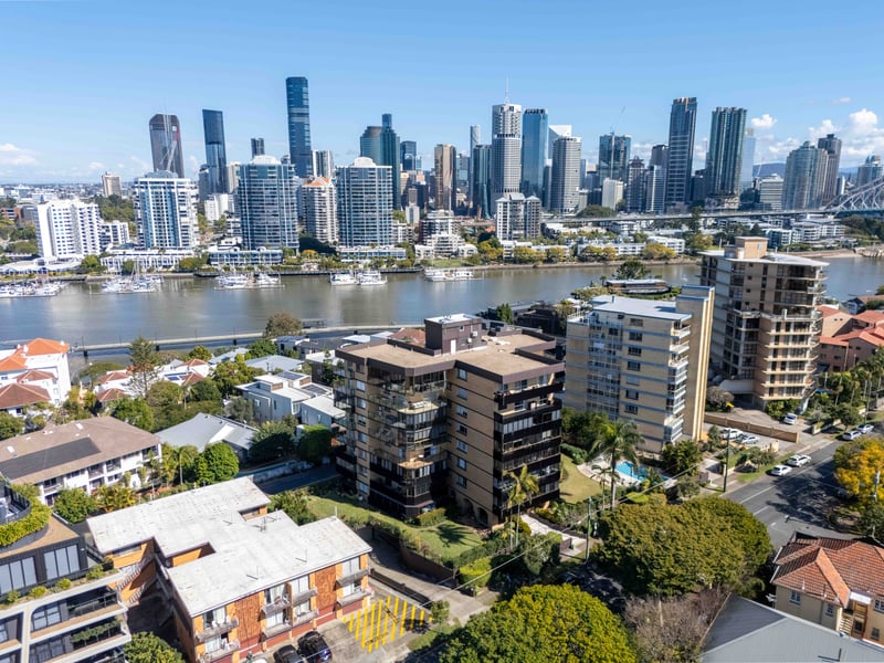 Aerial view of inner Brisbane apartments on the river with the city skyline behind