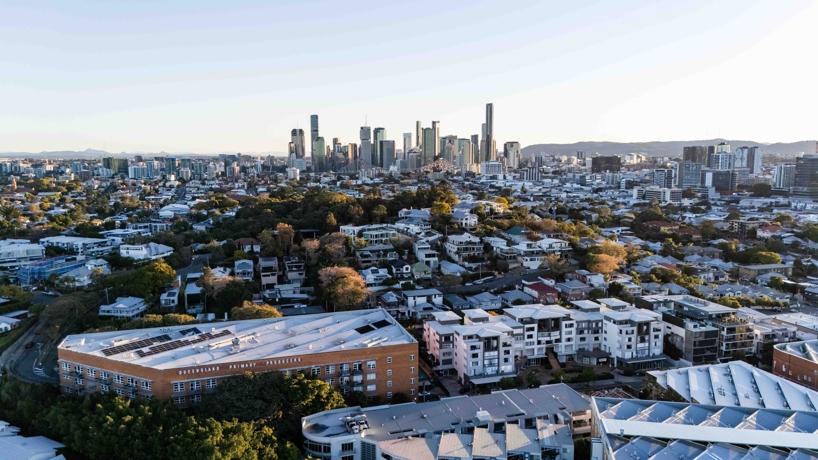 Aerial view across inner Brisbane rooftops to the city skyline