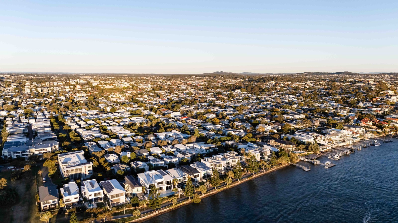 Aerial view of riverfront homes in Brisbane at sunset